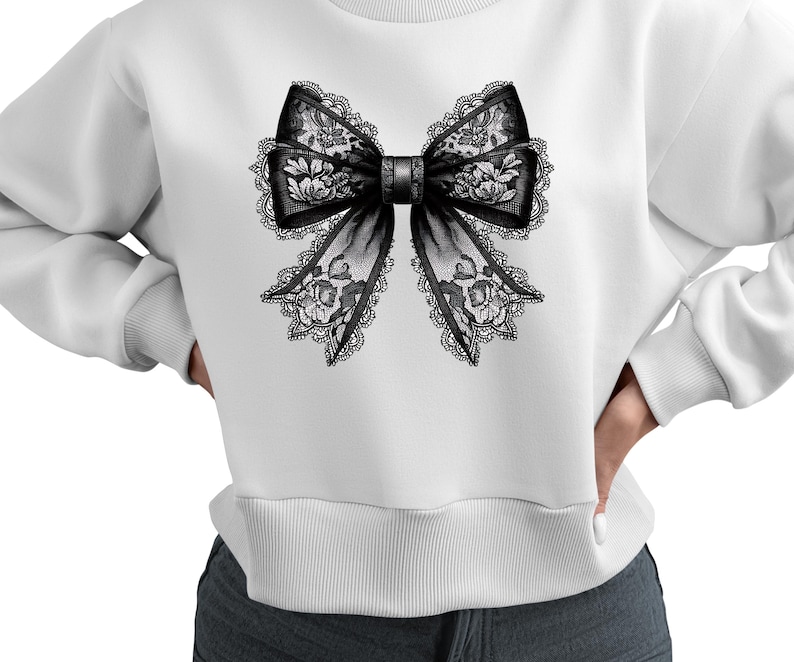May include: White sweatshirt with a black lace bow design on the front.