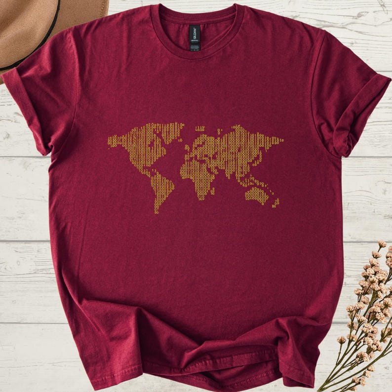 K&ouml;nnte beinhalten: Ein weinrotes T-Shirt mit einem goldfarbenen Weltkarten-Design. Die Karte besteht aus einem sich wiederholenden Muster, das eine strukturierte Optik erzeugt. Das Shirt hat kurze &Auml;rmel und einen Rundhalsausschnitt.