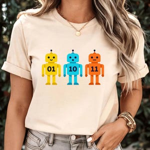 Puede incluir: Un juego de tres tazas de cerámica con un acabado mate moteado. Las tazas son de color crema, gris claro y gris oscuro. Cada taza tiene un diseño simple y minimalista y un asa redondeada.