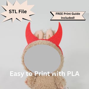 May include: A plush toy with a devil horn headband. The headband is red with glitter, and the toy has a tan fur-like texture. Text on the image reads "STL File" and "Easy to Print with PLA". A banner reads "FREE Print Guide Included!"