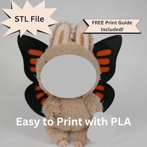May include: A plush toy with a bunny-like head and butterfly wings. The wings are black with orange accents. The toy has a light brown body and pink feet. Text on the image reads "STL File", "FREE Print Guide Included!", and "Easy to Print with PLA".