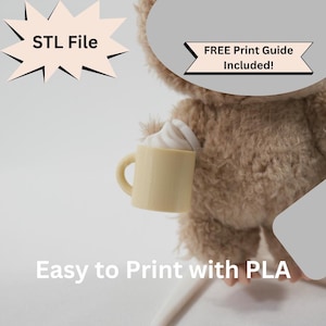May include: A plush, light brown teddy bear holding a small, yellow mug with a white whipped cream topping. Text on the image reads "STL File" and "FREE Print Guide Included!" and "Easy to Print with PLA".