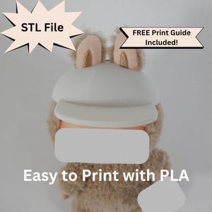 May include: A plush toy with a white cap and tan fur, featuring text that reads "STL File" and "FREE Print Guide Included!" The text "Easy to Print with PLA" is also visible. The toy has pink and gold accents.