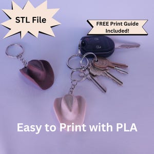 May include: Two cowboy hat keyrings, one brown and one light pink, next to a set of keys. The keyrings are attached to silver keyrings. Text in the image reads "STL File", "FREE Print Guide Included!", and "Easy to Print with PLA".