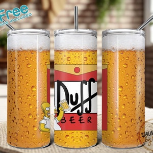 May include: A stainless steel tumbler with a design of a beer can featuring the text "Duff Beer" and a cartoon character holding a beer. The tumbler is filled with a yellow liquid that resembles beer and has condensation droplets on the outside.