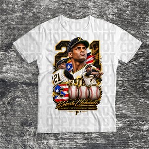 May include: A white t-shirt featuring a graphic of Roberto Clemente in a baseball uniform with the number 21, the Puerto Rican flag, three baseballs, and the text 3000, Roberto Clemente, 3000 Hits, #21, and Puerto Rico's Greatest.