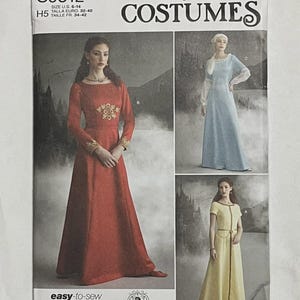 May include: Simplicity Costumes sewing pattern S9812, featuring medieval-style dresses. The pattern includes a red dress with gold embroidery, a light blue dress, and a yellow dress. The package is marked "easy-to-sew" and printed in the USA.