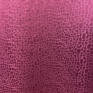 May include: Close-up of a textured fabric in a deep magenta hue. The fabric features a repeating pattern of irregular, interconnected shapes, creating a crocodile skin effect. The lighting highlights the subtle variations in texture.