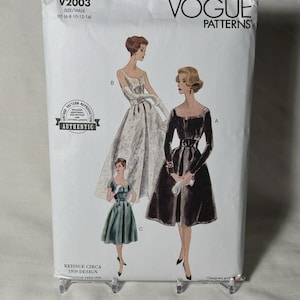 May include: A vintage Vogue Patterns sewing pattern, featuring illustrations of three elegant dresses. The package is white with the text "V2003" and "VOGUE PATTERNS". Includes a "Vintage Pattern Reproduction" seal and "REISSUE CIRCA 1959 DESIGN" text.