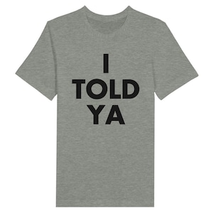 Puede incluir: Una camiseta gris jaspeada con texto negro que dice "I TOLD YA".