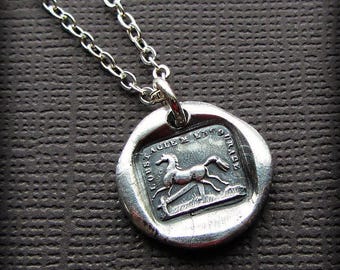 May include: A silver-toned pendant necklace featuring a circular wax seal design. The center depicts a horse in motion with the text LOUSTAGLE M LNSO URASE embossed around the edges. The pendant hangs from a delicate silver-toned chain link.