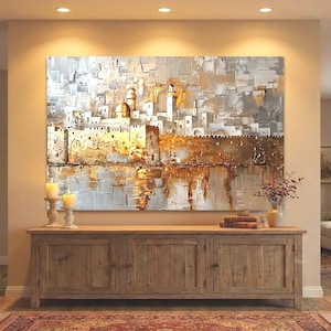 May include: A large rectangular wall art piece featuring an abstract, textured oil painting of a city skyline with a prominent golden dome. The color palette consists of metallic gold, white, gray, and silver tones with thick, visible brushstrokes.