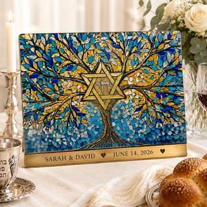 May include: A rectangular plaque featuring a mosaic tree of life with blue, teal, and gold leaves surrounding a central gold Star of David with Hebrew text. The base is a gold metal plate engraved with "SARAH & DAVID" and "JUNE 14, 2026".
