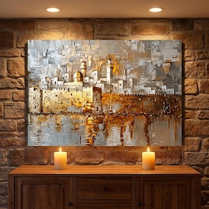 May include: A rectangular wall art piece featuring an abstract, textured oil painting of a city skyline with a prominent golden dome and towers. The color palette consists of metallic gold, white, and shades of gray, applied with thick brushstrokes.