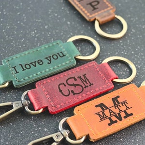 May include: Four leather keychains with metal rings. The keychains are engraved with different messages: "I love you", "CSM", and "M MATT IVI".
