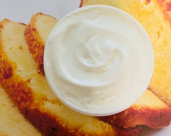 May include: A white bowl filled with whipped cream, next to slices of yellow pound cake.