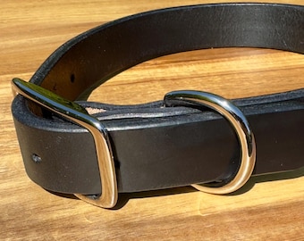 May include: A black leather dog collar with a silver buckle and D-ring.