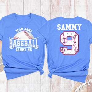 May include: Two blue t-shirts with a baseball theme. The front shirt has the text "TEAM NAME BASEBALL SAMMY #9" with a baseball graphic. The back shirt has the text "SAMMY" and the number "9" with a baseball graphic.