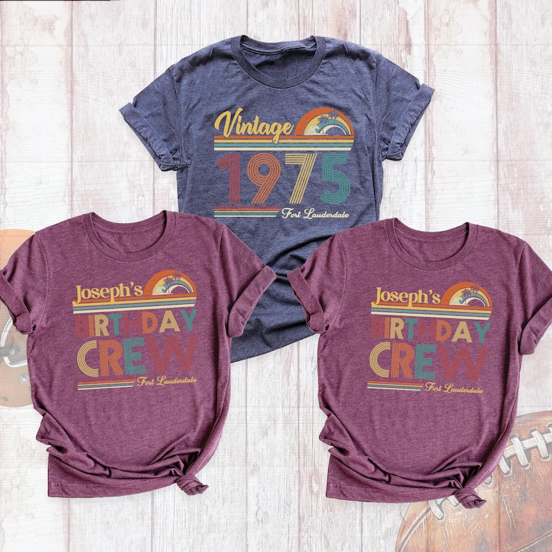 May include: Three t-shirts with a vintage 1970s theme. One navy blue t-shirt says "Vintage 1975 Fort Lauderdale". Two maroon t-shirts say "Joseph's Birthday Crew Fort Lauderdale".