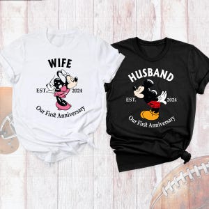 Puede incluir: Dos camisetas blancas con texto negro e im&aacute;genes. La primera camiseta dice "Wife Est. 2024 Our First Anniversary" y presenta una imagen de dibujos animados de Minnie Mouse besando a Mickey Mouse. La segunda camiseta dice "Husband Est. 2024 Our First Anniversary" y presenta una imagen de dibujos animados de Mickey Mouse besando a Minnie Mouse.
