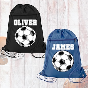 May include: A black drawstring bag with the name OLIVER and a soccer ball graphic, and a blue drawstring bag with the name JAMES and a soccer ball graphic. Both bags feature a zippered front pocket and black cord straps for closure.