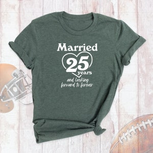 May include: A dark green t-shirt with white text that reads "Married 25 years and looking forward to forever". The text is in a heart shape with the number 25 inside.