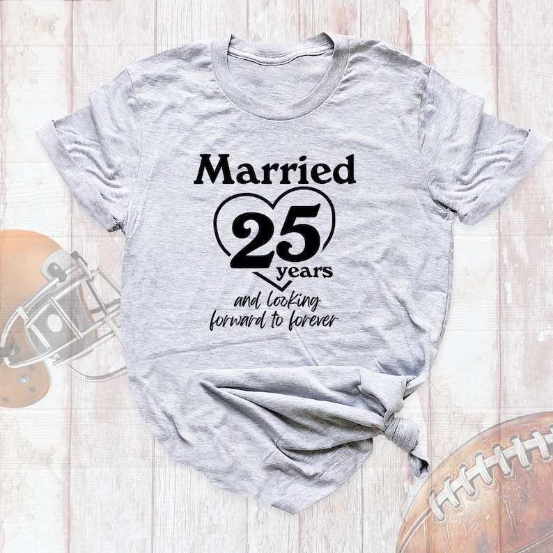 May include: A gray t-shirt with the text "Married 25 years and looking forward to forever" printed in black. The text is inside a heart shape.