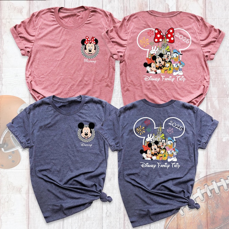 Puede incluir: Dos camisetas de manga corta, una rosa polvoriento y otra azul marino, con gr&aacute;ficos de personajes de Disney. La parte delantera de cada camiseta tiene la cara de un personaje con un nombre. La parte trasera tiene un gr&aacute;fico del castillo de Disney y el texto "Disney Family Trip 2025."