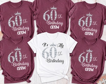 May include: Four maroon t-shirts and one white t-shirt. The maroon shirts feature a silver diamond-patterned 60th Birthday Crew graphic with a crown. The white shirt features a silver diamond-patterned 60th Birthday graphic with a crown.