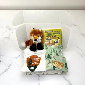 Coffret cadeau baby shower Parc national aventure : barboteuse en mousseline 0-3 mois, cartes jalons, grenouillère, peluche renard et livre