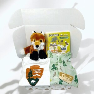 Nationalpark Babyparty Geschenkbox Abenteuer-Set: 0-3 Monate Musselin-Strampler, Meilensteinkarten, Strampelanzug, Fuchs-Plüschtier & Buch