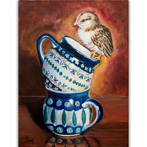 May include: A painting of a small brown and white chick perched on top of a stack of three blue and white ceramic mugs. The mugs have a traditional folk art design with green, white, and blue patterns.