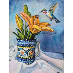May include: A painting of a hummingbird hovering near a bouquet of yellow lilies in a blue and white ceramic mug. The mug has a floral pattern and a hummingbird design. The background is a light blue.