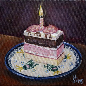 May include: A single slice of layered cake with pink, white, and chocolate frosting, topped with a lit candle, on a blue and white patterned plate.