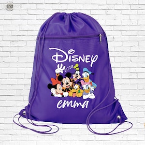 May include: A purple drawstring backpack featuring a white graphic of Disney characters including Mickey Mouse, Minnie Mouse, Goofy, Donald Duck, Daisy Duck, and Pluto. The text reads Disney 2026 and the name emma in white script font.