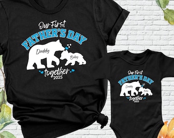 May include: Black t-shirt and onesie set with a graphic of two bears. The text on the shirts reads "Our First Father's Day Daddy Baby Together 2025".