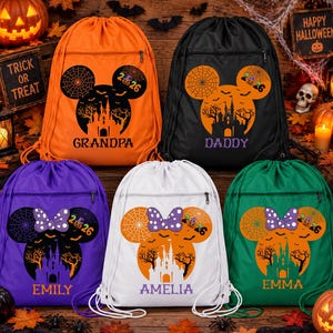 May include: Five drawstring backpacks in orange, black, purple, white, and green. Each bag features a graphic of a mouse-shaped silhouette containing a castle, trees, and a spiderweb, with the text 2026 and a personalized name below.