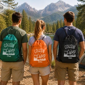 May include: Three drawstring backpacks in green, orange, and black, each featuring white screen-printed text that reads COUSIN CAMP 2024 with a graphic of a tent and pine trees, plus a personalized name at the bottom of the design.