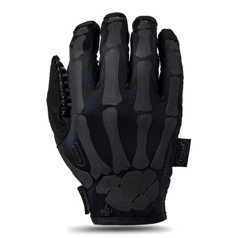 May include: A black tactical glove featuring a dark gray skeleton hand print on the back. The glove includes a small black tag with the text TACLAB on the side, a textured grip area on the thumb, and a small logo with the text TTRS at the wrist.