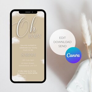 May include: A beige mobile phone screen with a baby shower invitation. The invitation has a white cloud background with the text "Oh Baby" in a cursive font. The text also includes the name "Sarah", the date "6th July 2pm", the address "45 Main Street, Somewhere, LH1 1LH", and the request to RSVP by July 1st to Jessica at 01234 56789. The phone screen has a black border and the Canva logo is in the bottom right corner.