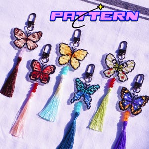 Op de afbeelding: Een verzameling vlinder sleutelhangers in verschillende kleuren, waaronder geel, rood en blauw. Elke sleutelhanger heeft een kralen accent en een kwast. Het woord "PATTERN" wordt weergegeven in een paarse en blauwe letter.