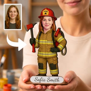 May include: A custom wooden figurine of a firefighter with red hair, wearing a tan uniform with yellow reflective stripes and a red helmet labeled FIRE. The figure holds a red axe and stands on a base with the name Sofia Smith printed on it.