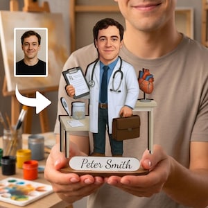 May include: A custom caricature figurine of a doctor wearing a white coat, blue shirt, and tie, holding a clipboard and a brown briefcase. The figure stands on a wooden base with the name Peter Smith printed on a white plaque, next to a desk.