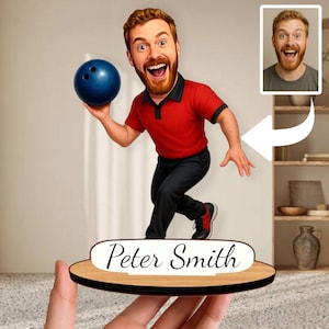 Peut inclure: Une caricature personnalisée sur le thème du bowling d'un homme aux cheveux roux et à la barbe, portant un polo rouge et un pantalon noir, tenant une boule de bowling bleue. La base porte le nom "Peter Smith".