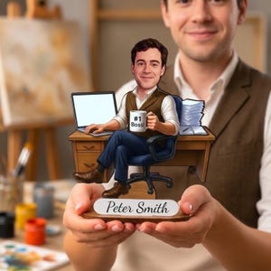May include: A custom caricature desk ornament featuring a cartoon figure sitting in an office chair at a wooden desk with a laptop, a stack of papers, and a mug labelled #1 Boss. The base is a wooden plaque with the name Peter Smith printed on it.