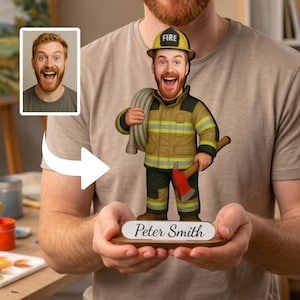 Könnte beinhalten: Eine personalisierte Wackelfigur, die eine lächelnde Person mit rotem Bart in einer beigefarbenen und schwarzen Feuerwehruniform zeigt, mit einem gelben Helm mit der Aufschrift FIRE, die einen aufgerollten Schlauch und eine Axt hält, auf einem Sockel mit dem Namen Peter Smith.