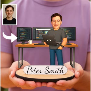 Peut inclure: Illustration de dessin animé d'une personne tenant une base en bois avec une scène de bureau miniature. Le bureau comprend deux écrans d'ordinateur affichant du code, un ordinateur portable avec un symbole de codage et une tasse à café. La base porte le nom "Peter Smith".