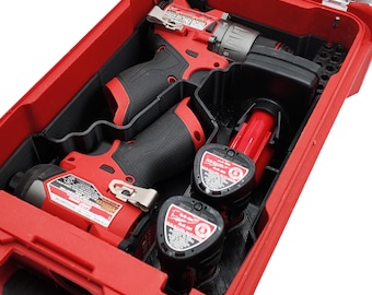 Puede incluir: Un kit de herramientas rojo y negro con tapa transparente. El kit contiene un taladro, un atornillador de impacto y dos baterías. Las herramientas son rojas y negras, y las baterías son negras con detalles rojos. El kit está diseñado para sujetar las herramientas de forma segura.