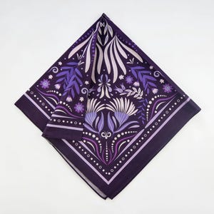 May include: A purple bandana with a floral pattern. The pattern features white and purple flowers, leaves, and swirls. The bandana has a dark purple background and a white border.
