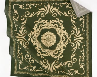 Könnte beinhalten: Dunkelgrünes Bandana mit beigem floralem Design. Das quadratische Tuch zeigt ein zentrales Blumenemblem, das von verzierten Schnörkeln und einem dekorativen Rand umgeben ist. Der Text "#JJ24012A TX USA" ist unten links aufgedruckt.